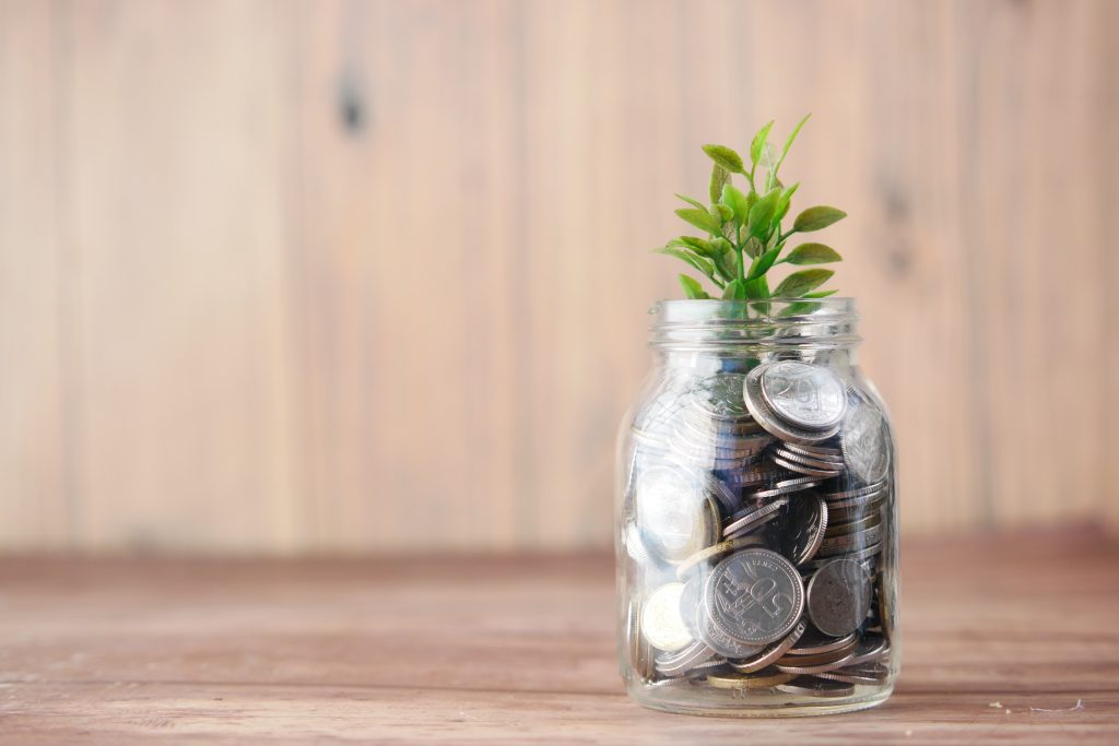 a glass jar filled with coins and a plant like Investment 