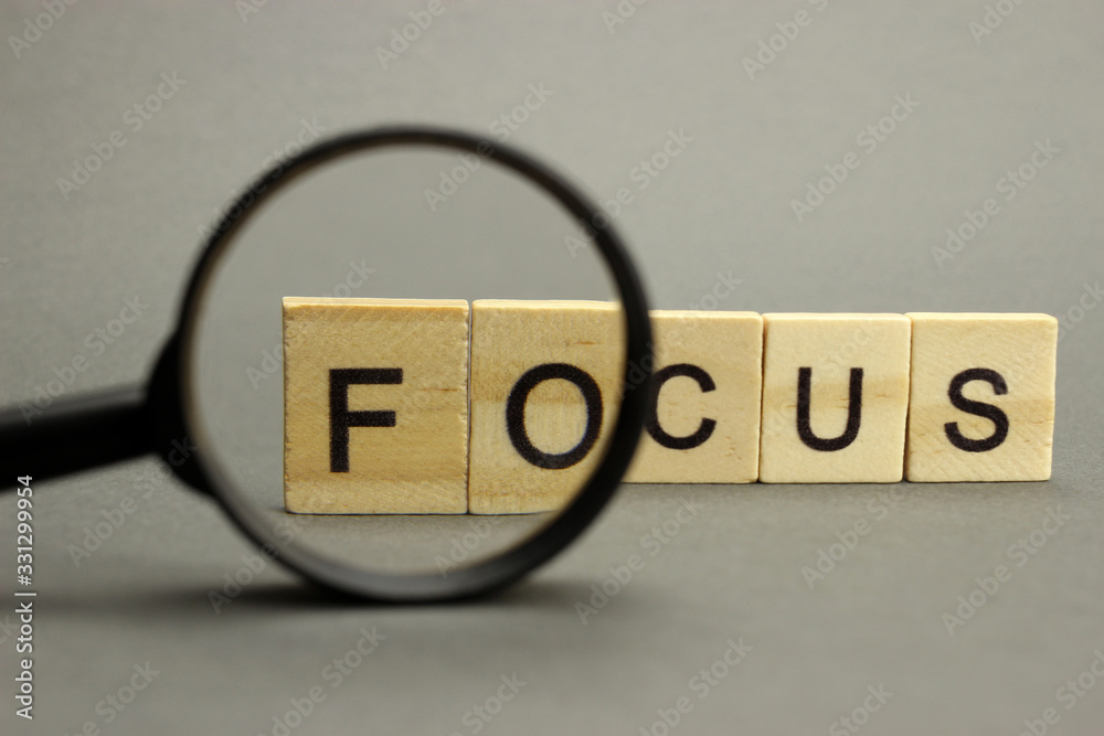 The word focus is made of wooden letters with a magnifying glass. Selective focus
Managing Distractions for Productivity